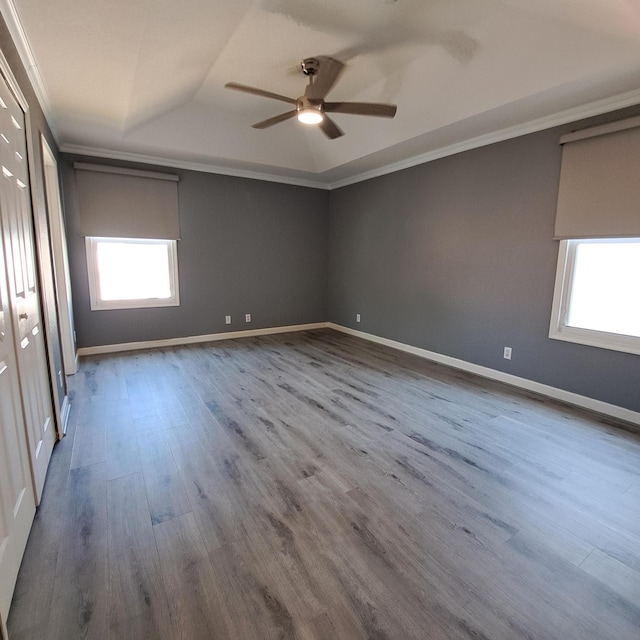 unfurnished bedroom with ceiling fan, wood finished floors, baseboards, and ornamental molding