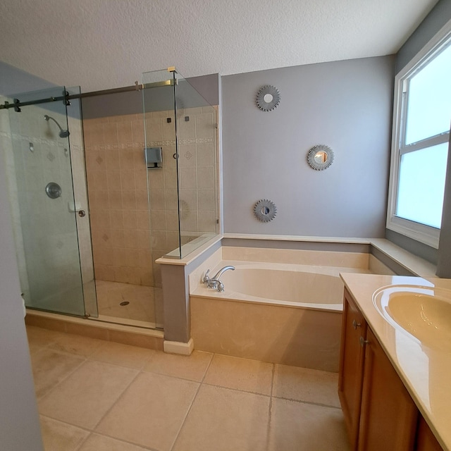 bathroom with vanity, a garden tub, a shower stall, and a textured ceiling