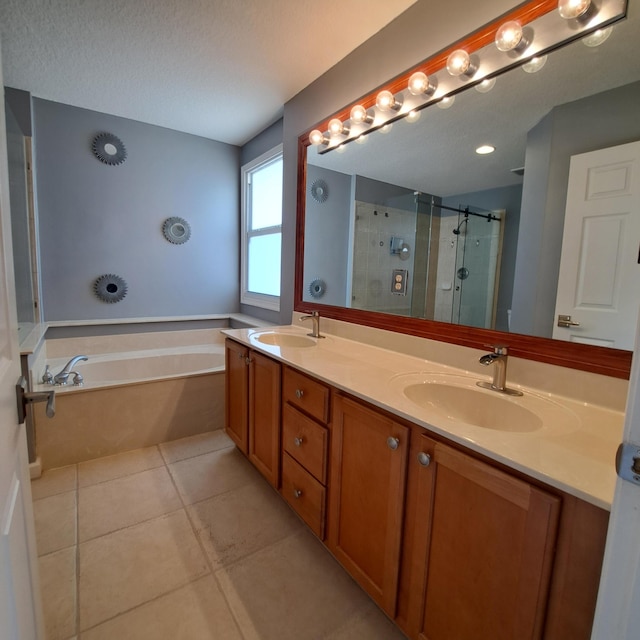 bathroom featuring double vanity, a shower stall, tile patterned floors, and a sink