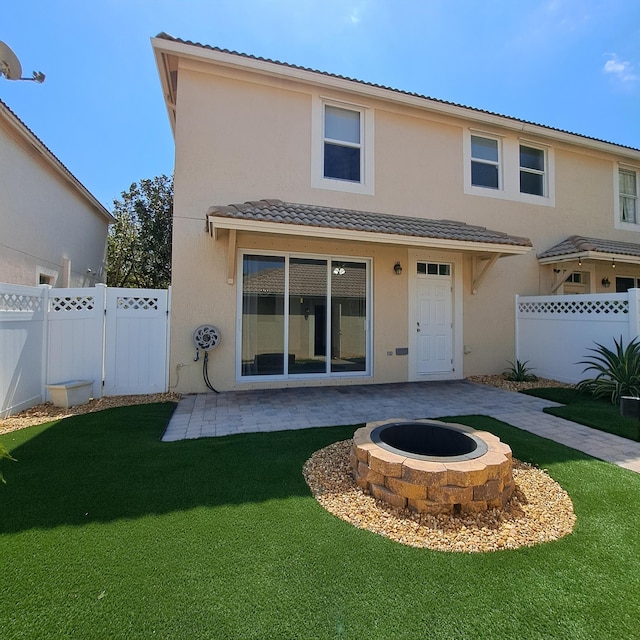 back of house with a patio area, a yard, a fire pit, and a fenced backyard