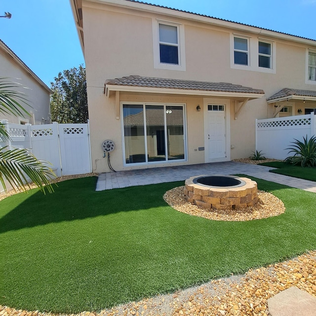 back of property with a patio area, fence, a lawn, and stucco siding