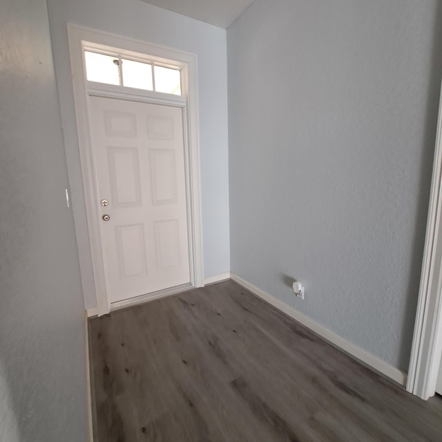 entryway with dark wood-type flooring and baseboards