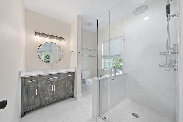 full bath with visible vents, toilet, a shower stall, baseboards, and vanity