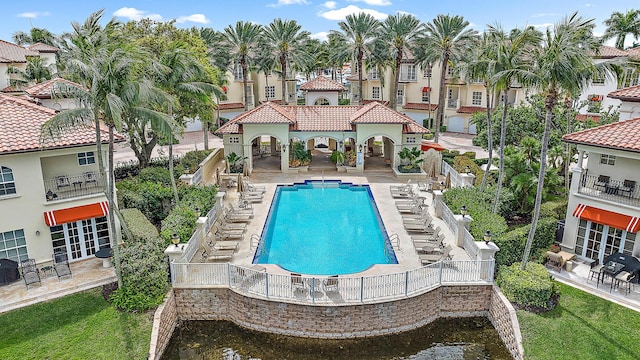 pool featuring stairway, a patio, and a lawn