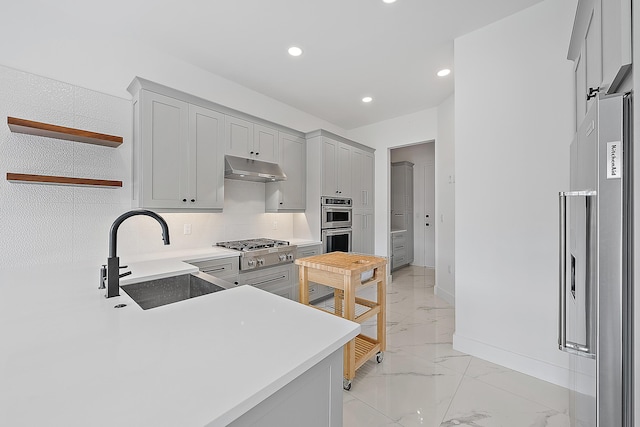 kitchen with marble finish floor, a sink, open shelves, under cabinet range hood, and stainless steel appliances