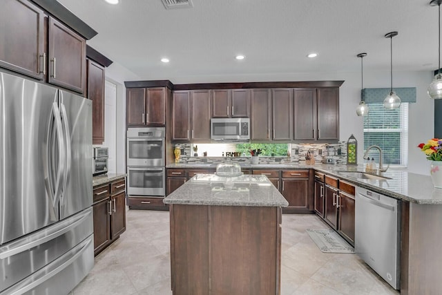 kitchen with a kitchen island, a peninsula, a sink, decorative backsplash, and stainless steel appliances