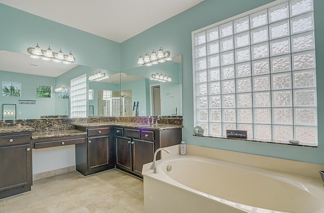 bathroom featuring plenty of natural light, vanity, and a garden tub