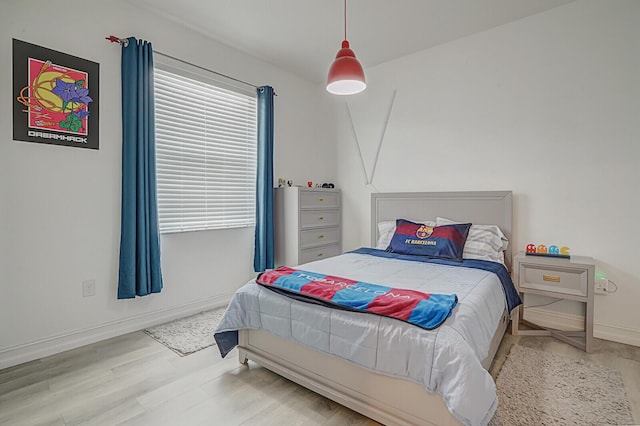 bedroom featuring baseboards and wood finished floors