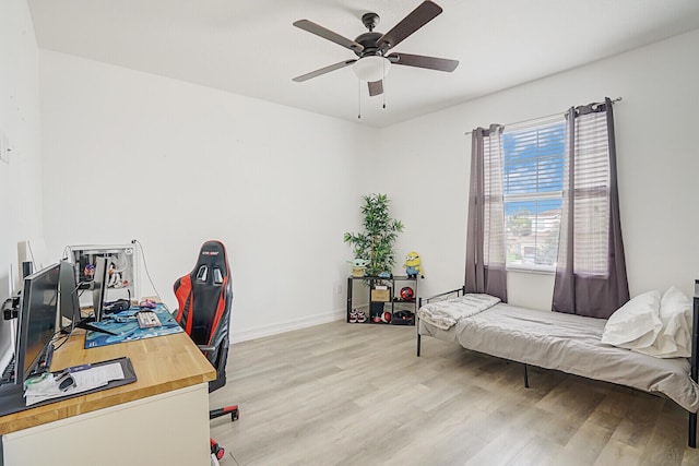 office space with light wood finished floors, baseboards, and a ceiling fan