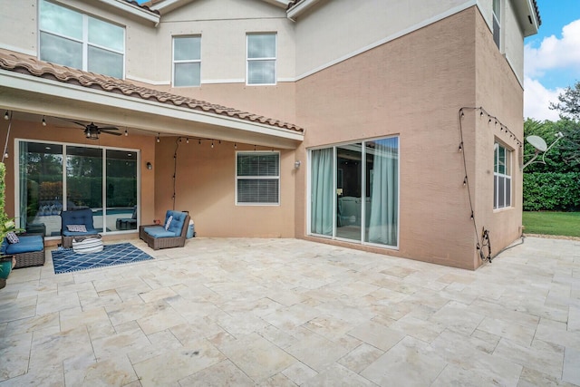 back of house with ceiling fan, a tiled roof, a patio area, and stucco siding