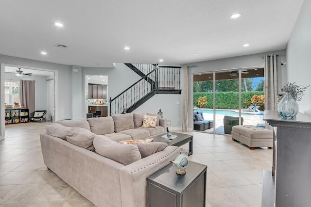 living area with a wealth of natural light, visible vents, recessed lighting, and stairway