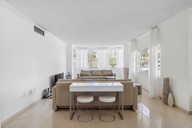 interior space featuring crown molding, light tile patterned floors, visible vents, and a textured ceiling