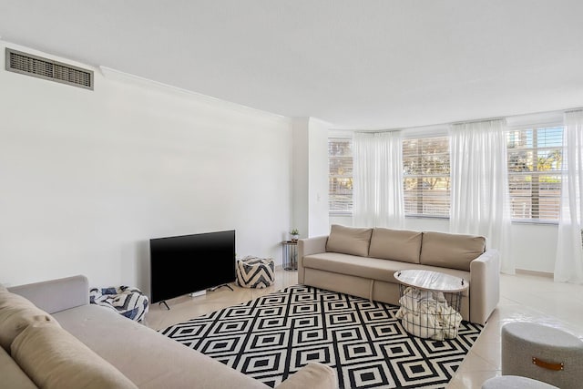 living area featuring visible vents and crown molding