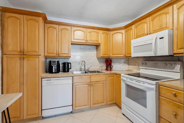 kitchen with a sink, white appliances, backsplash, and light countertops