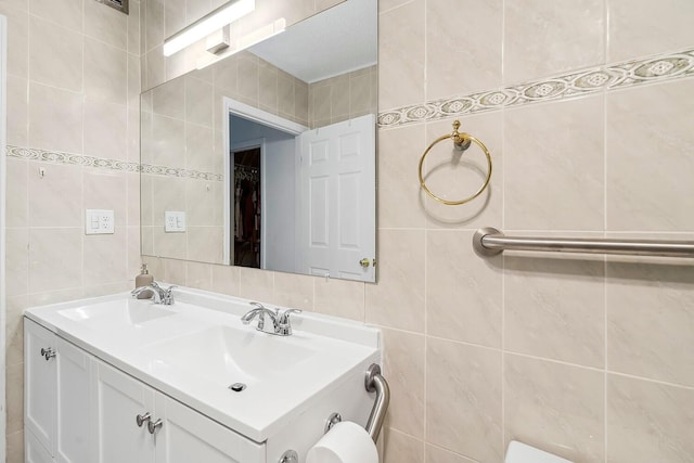 bathroom featuring a sink, tile walls, and double vanity