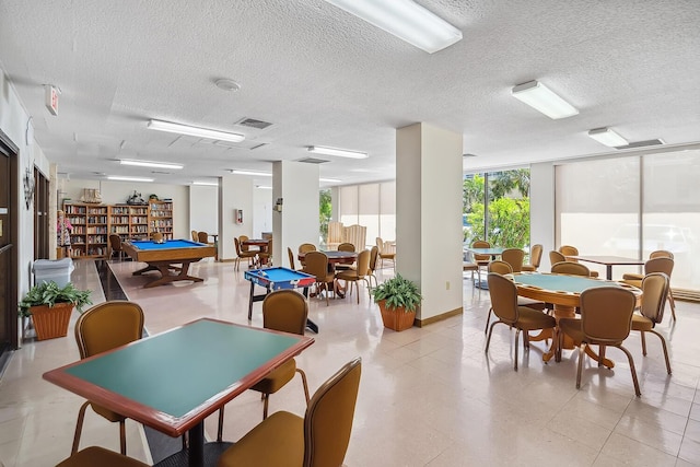 dining area featuring floor to ceiling windows, visible vents, and a textured ceiling