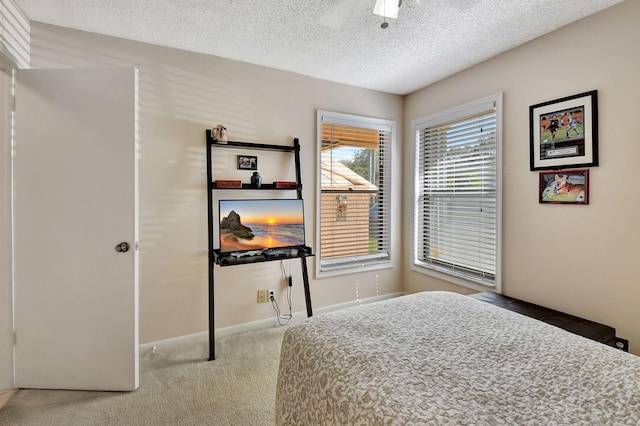 bedroom with baseboards, carpet, a ceiling fan, and a textured ceiling