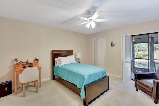 bedroom with access to outside, light colored carpet, baseboards, and a textured ceiling