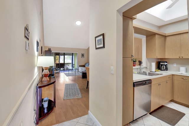 kitchen featuring light brown cabinets, a sink, light tile patterned flooring, light countertops, and dishwasher