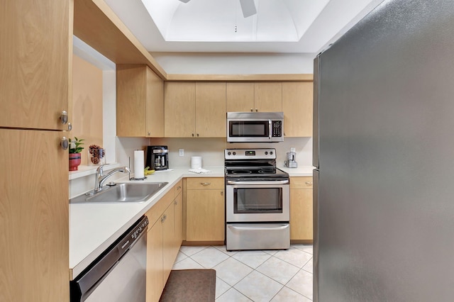 kitchen with light tile patterned floors, light brown cabinets, appliances with stainless steel finishes, and a sink