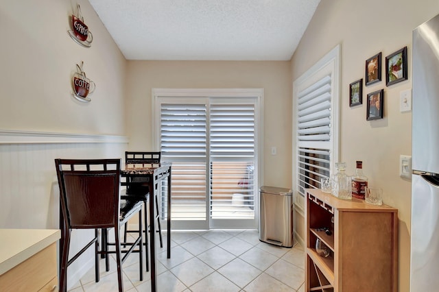 dining space featuring light tile patterned floors and a textured ceiling