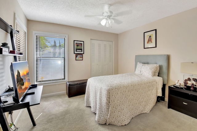 bedroom featuring a closet, baseboards, a textured ceiling, and carpet flooring