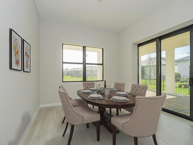 dining space with baseboards and plenty of natural light