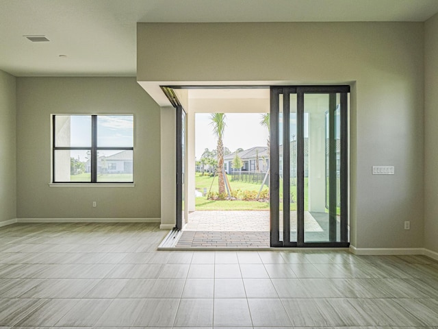 doorway featuring tile patterned floors, visible vents, and baseboards