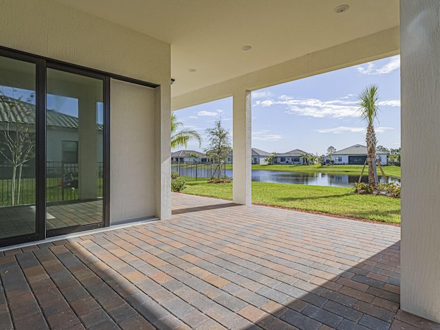 deck with a patio area, a water view, a residential view, and a lawn