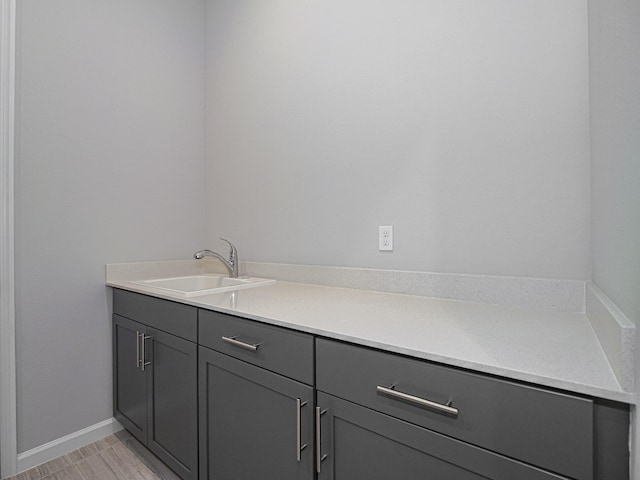 bathroom featuring baseboards and a sink