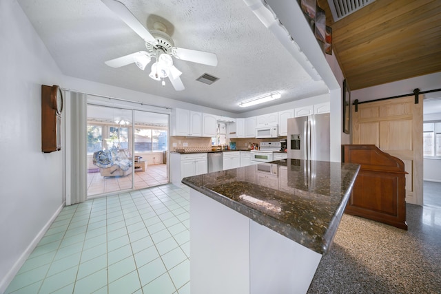 311 Granada St, Fort Pierce, FL 34949 - kitchen with stainless steel appliances, a ceiling fan, white cabinetry, baseboards, and plenty of natural light