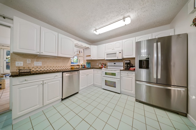 311 Granada St, Fort Pierce, FL 34949 - kitchen featuring stainless steel appliances, a sink, backsplash, white cabinetry, and a textured ceiling