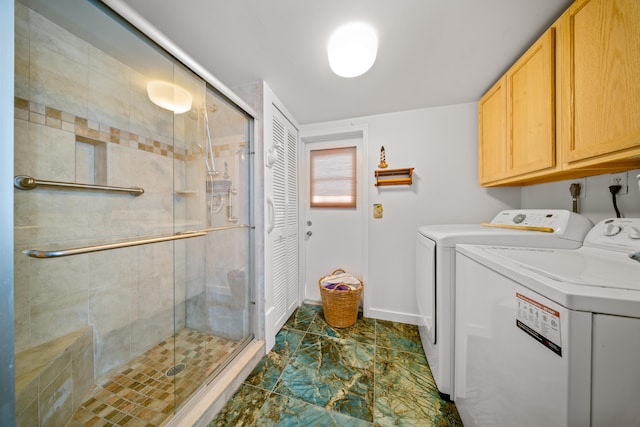laundry area featuring washing machine and clothes dryer, cabinet space, and baseboards