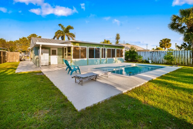 view of pool featuring a sunroom, a fenced backyard, a fenced in pool, a yard, and a patio area