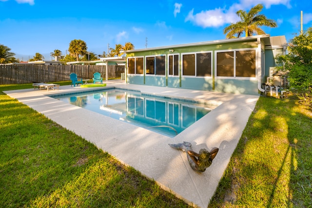 view of pool featuring a fenced backyard, a fenced in pool, a sunroom, and a yard