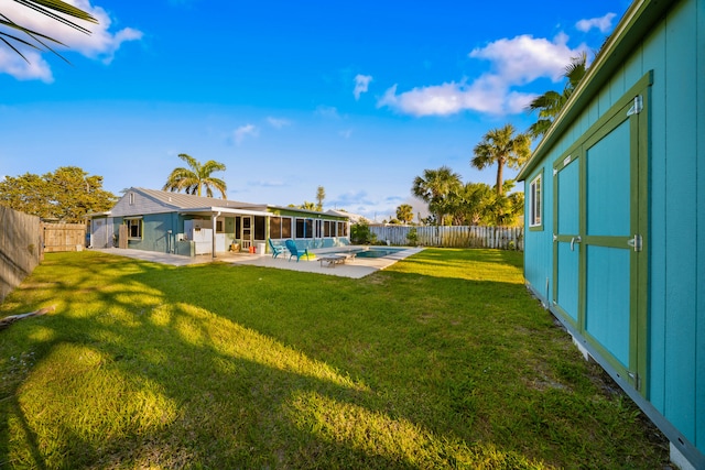 view of yard featuring a patio, a sunroom, and a fenced backyard