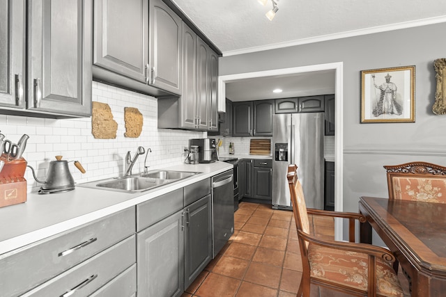 kitchen featuring a sink, gray cabinetry, stainless steel appliances, crown molding, and tasteful backsplash