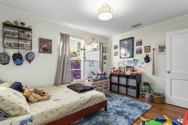 bedroom featuring visible vents and wood finished floors