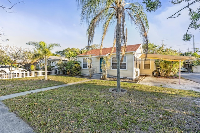 bungalow-style house with a front lawn, fence, and crawl space