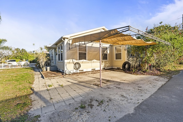 view of front facade featuring crawl space, a carport, and fence