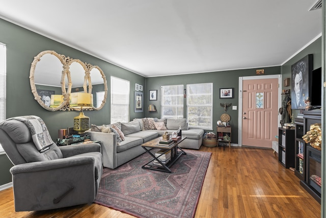 living room with visible vents, baseboards, and wood finished floors