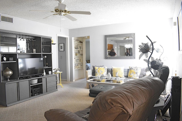 living area with visible vents, a textured ceiling, carpet, and a ceiling fan