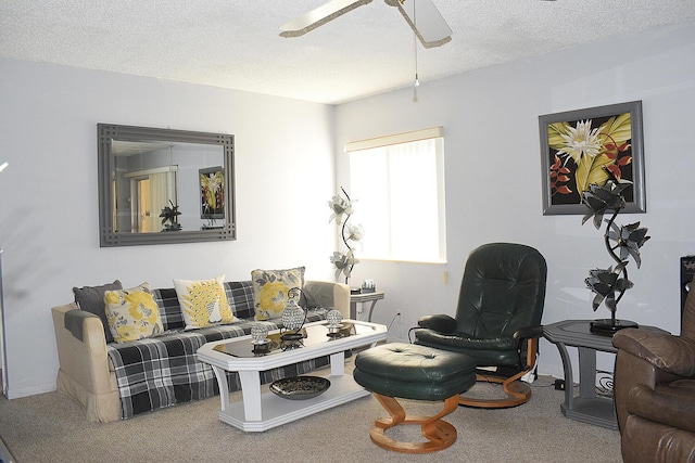 carpeted living area with a textured ceiling and ceiling fan