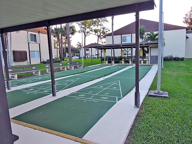 view of property's community with a yard and shuffleboard