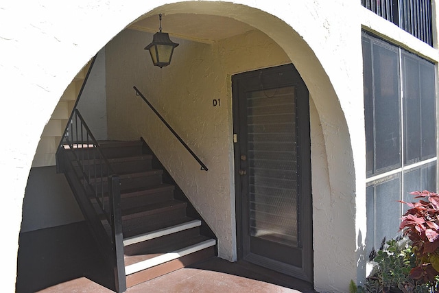 entrance to property featuring stucco siding