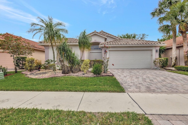 mediterranean / spanish-style house with stucco siding, a tile roof, decorative driveway, and a garage