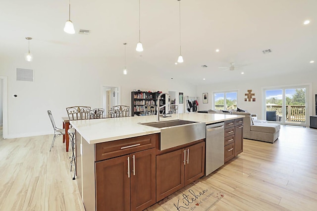 kitchen featuring light wood finished floors, visible vents, a center island with sink, and stainless steel dishwasher