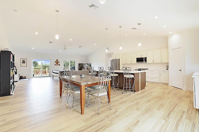 dining area with recessed lighting, visible vents, high vaulted ceiling, and light wood finished floors