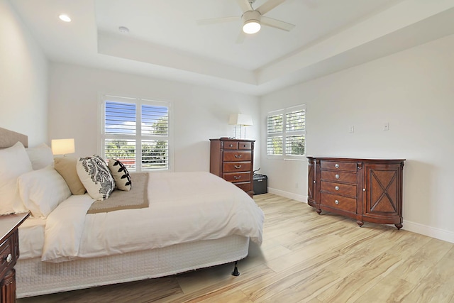 13327 Marcella Blvd, Loxahatchee Groves, FL 33470 - bedroom featuring a tray ceiling, light wood-style flooring, baseboards, and ceiling fan