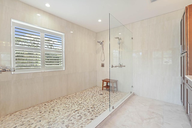 bathroom featuring tile walls, recessed lighting, a walk in shower, and marble finish floor